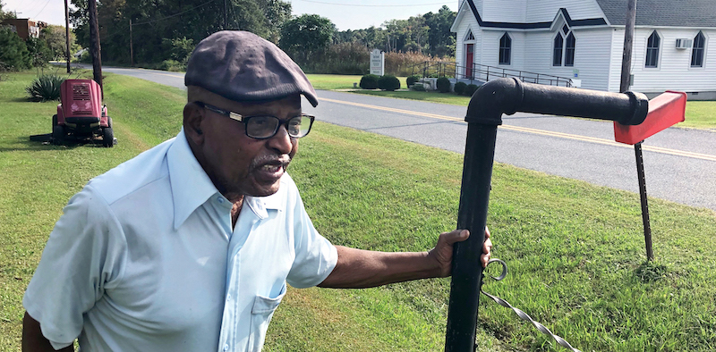 Despite heat and mosquitoes, Luther Cornish mows his lawn several times a week in the summer to keep the drainage area clear.