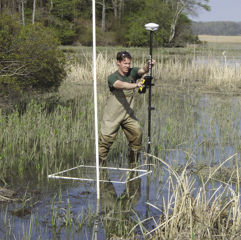 Whitley 'Whit' Saumweber, former program manager for the NOAA Estuarine Reserves Division, holds the GPS section of an RTK Base-Rover system to collect elevation data at Sweet Hall Marsh, one of the long-term transects of the Chesapeake Bay National Estuarine Research Reserve’s Sentinel Site. Photo, Scott B. Lerberg / VIMS