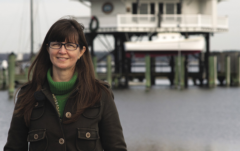 Jennifer Dindinger standing in front of Seven Foot Knoll Light lighthouse