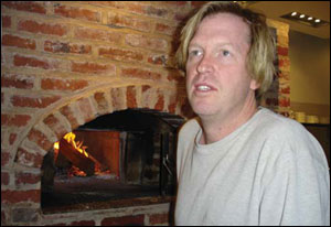 Chef Spike  Gjerde before a wood burning oven, photograph by Jessica Smits