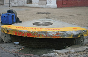 storm drain with Trash Kills Crabs painted on it - by Erica Goldman