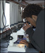student looking at a microscope