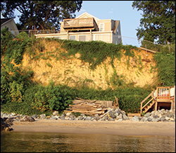 Erosion along the length of the cliffs threatens a home. Credit: David Brownlee