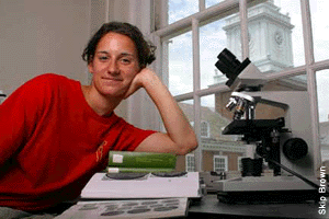 Angie Arnold sitting next to a dissecting microscope - by Skip Brown