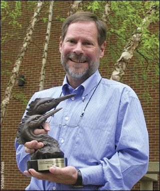 Jack Greer holding the President's Award for Execellence (heads of two herons)