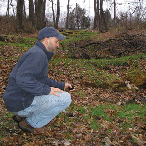 Drew Koslow crouching neaer a restored stream