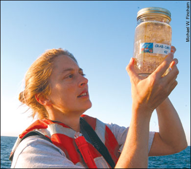 Elizabeth North holding a jar of crab larvae