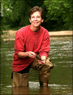 Margaret Palmer kneeling in the Paint Branch Creek
